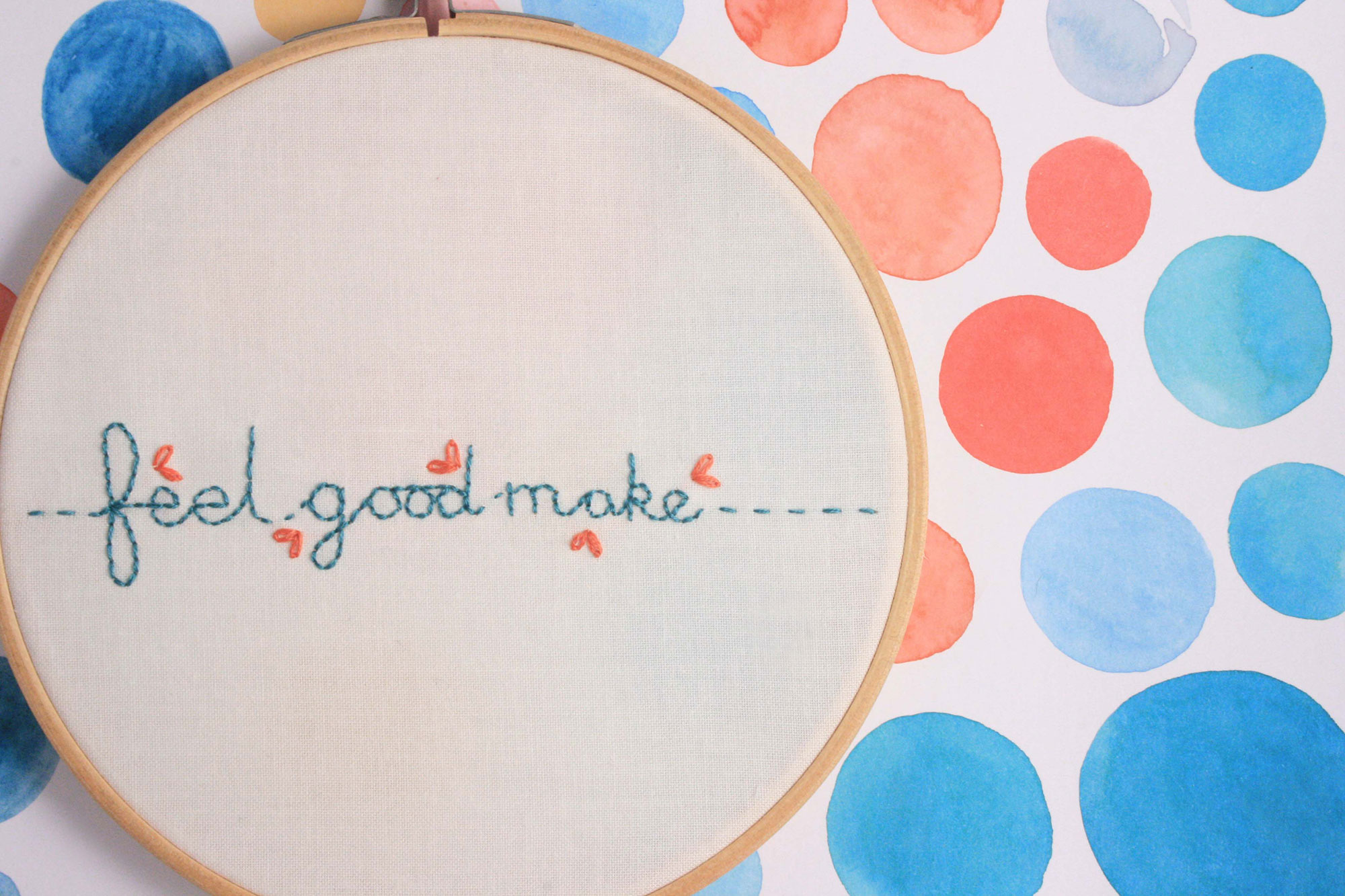 detailled photo of embroidery with words feel good make in teal and orange thread