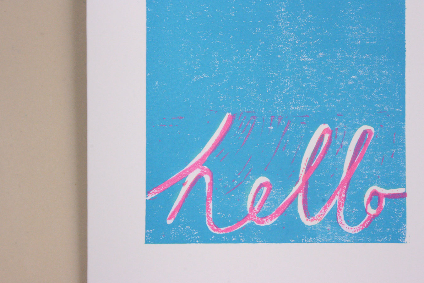 lino cut card with message saying hello in neon pink and turquoise