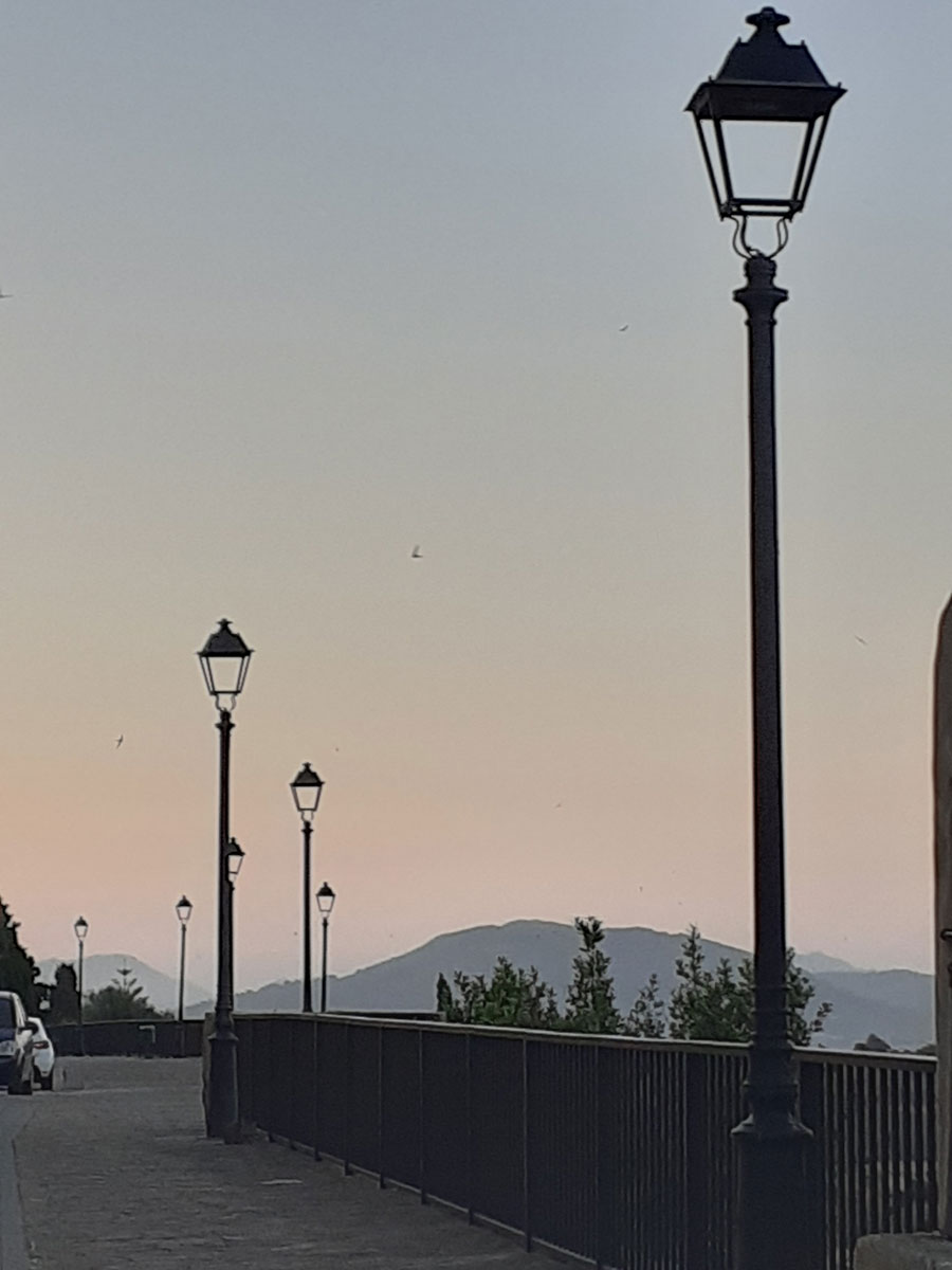 lampposts silhouetted against a dusky sky