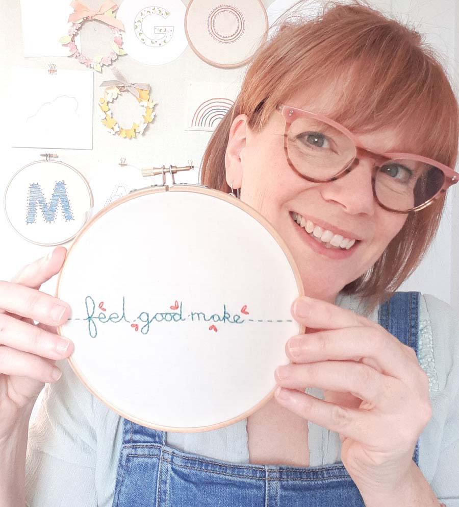 photo of artist Hannah Walker holding up her embroidery