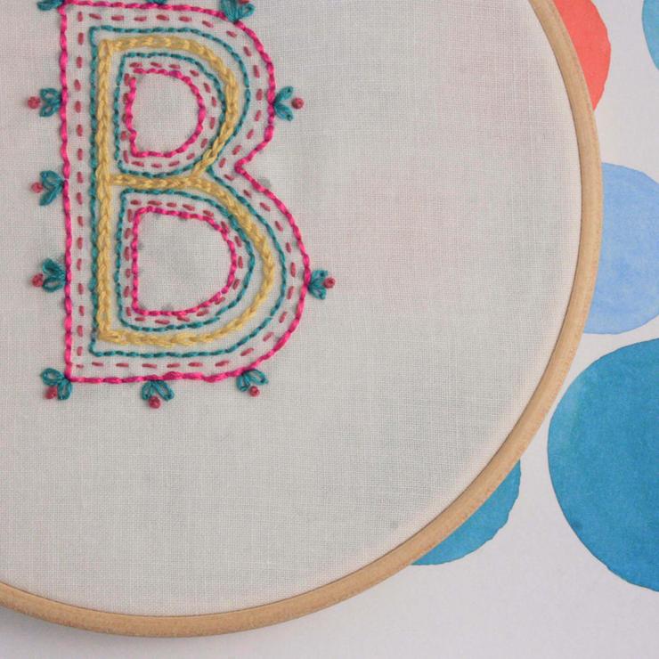 hand embroidered letter B in shades of neon pink turquoise and yellow