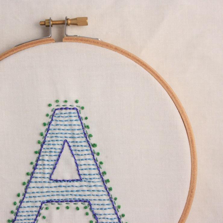 hand embroidered letter A in shades of blue and green